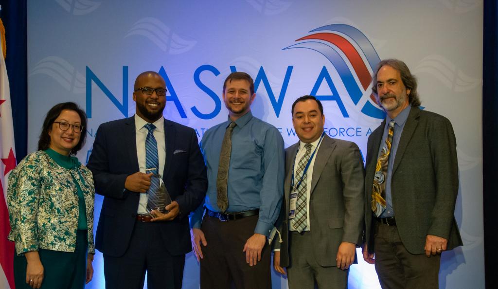 Accepting the Pinnacle Award for Business Development, Ruben Pachay, Director, Eric Ramsay, John Paul, and Stuart Bass, Pennsylvania Department of Labor and Industry pose with Anna Hui, NASWA Board President