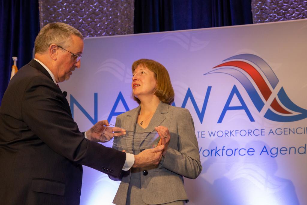 Carol Dobak, Acting Deputy Commissioner, Rehabilitation Services Administration, Office of Special Education and Rehabilitative Services, U.S. Department of Education accepts award from Scott Sanders, NASWA Executive Director